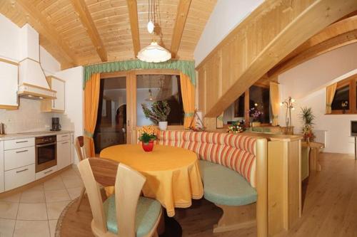 een keuken met een tafel en een bank en een tafel en een keuken bij Zollhof in Vipiteno