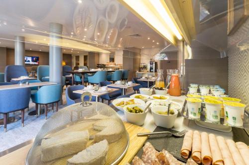 Un restaurante con una mesa con comida encima. en Résidence Pierre & Vacances Premium Presqu'Ile de la Touques, en Deauville