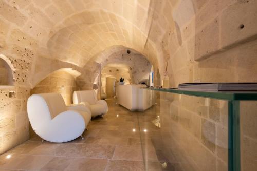 a large room with a large tub and a marble floor at Aquatio Cave Luxury Hotel & SPA in Matera