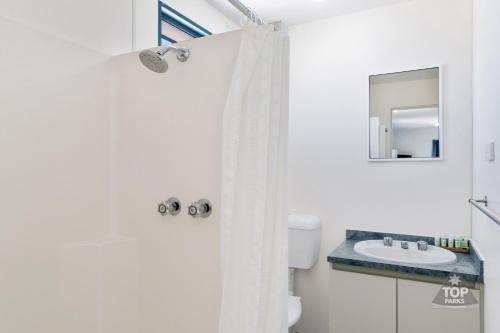 a bathroom with a white shower curtain and a sink at Tasman Holiday Parks - Denham Seaside in Denham