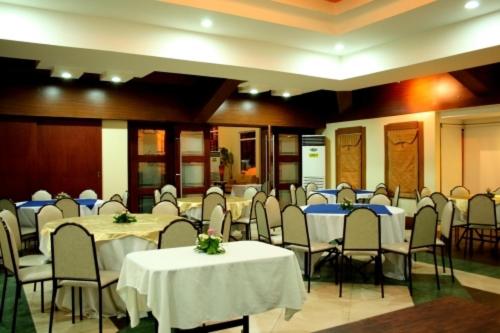 un salón de banquetes con mesas y sillas con manteles blancos en MO2 Westown Hotel - Mandalagan en Bacólod