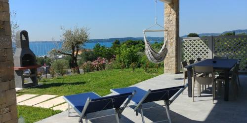 a patio with a hammock and a table and chairs at Relais Rosa Dei Venti -Ciao Vacanze- in Moniga