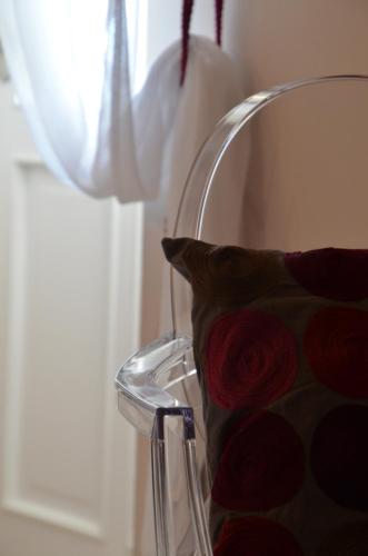 a chair with a pillow next to a window at La Petite Aiguebonne in Allex
