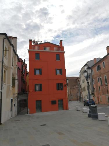 an orange building in the middle of a street at Mansarda Settimo Cielo in Chioggia