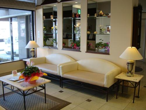 a living room with two couches and tables and mirrors at West Inn Fuji-Yoshida in Fujiyoshida