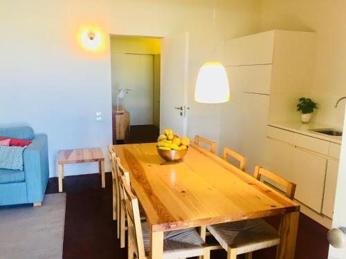 a kitchen with a wooden table with a bowl of fruit on it at Bernardas Convent Apartment in Tavira