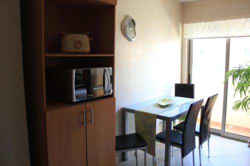 a kitchen with a table with chairs and a microwave at Sweet Dream House in Faro