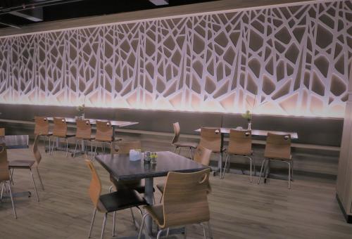 a restaurant with tables and chairs against a wall at Langkasuka Express in Kuah