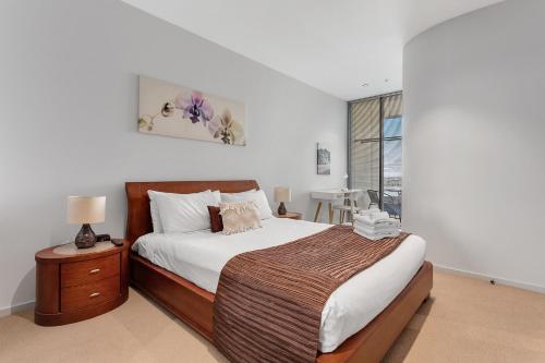 a bedroom with a bed and a dresser at Docklands Private Collection - NEWQUAY in Melbourne