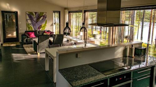 a kitchen with a counter top and a living room at Harjunranta in Kuusamo
