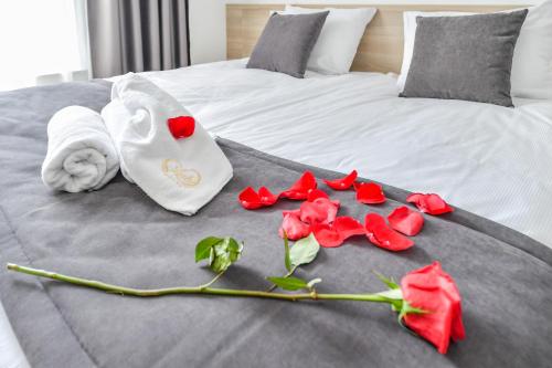 a bed with red roses and towels on it at Lubhotel in Lublin