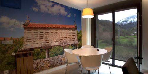 a room with a table and chairs and a large window at Apartamentos Rurales Las Vegas de Cardeo in Las Vegas De Cardeo