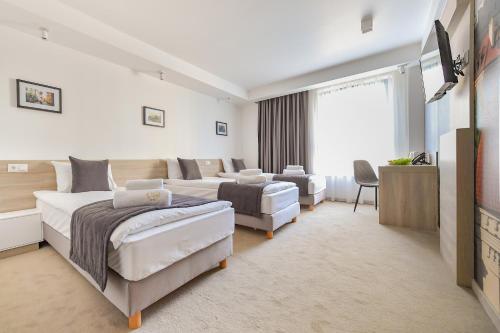 a bedroom with two beds and a living room at Lubhotel in Lublin