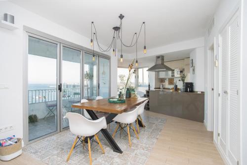 a kitchen with a wooden table and white chairs at Alicante Ocean View in Alicante