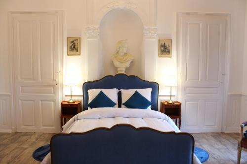 a bedroom with a blue bed and two lamps at Hôtel Le 43 in Luxeuil-les-Bains