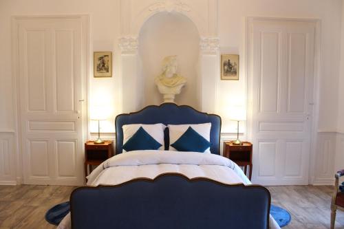 a bedroom with a blue bed and two lamps at Le Napoléon in Luxeuil-les-Bains