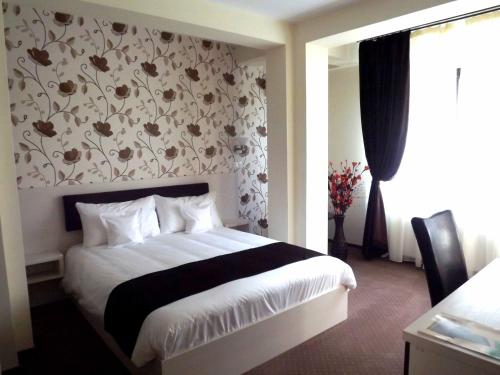 a bedroom with a bed with a floral wallpaper at West Plaza Residence in Bucharest