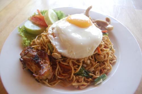 einen Teller Nudeln mit einem Ei oben drauf in der Unterkunft Star East Bungalows in Amed