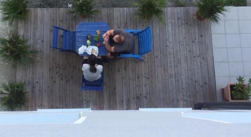a man sitting on a blue bench in front of a fence at Mariazeller Rooms in Mariazell