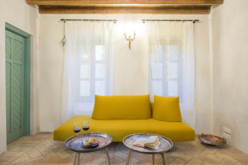 a yellow couch in a room with two tables at Tafros Villa in Rhodes Town