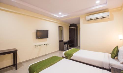a hotel room with two beds and a tv at Hotel City Center Jodhpur in Jodhpur
