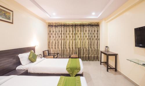 a hotel room with two beds and a television at Hotel City Center Jodhpur in Jodhpur
