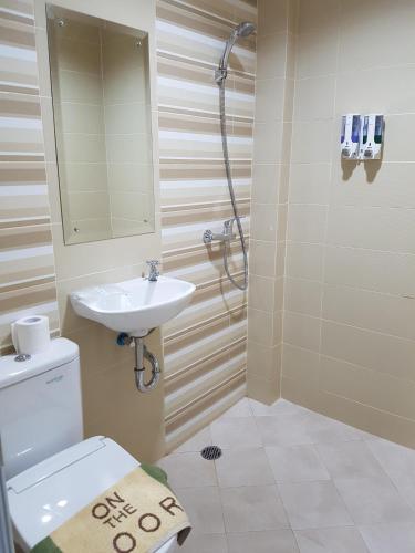 a bathroom with a toilet and a sink and a shower at Ethan Hotel Kelapa Gading in Jakarta