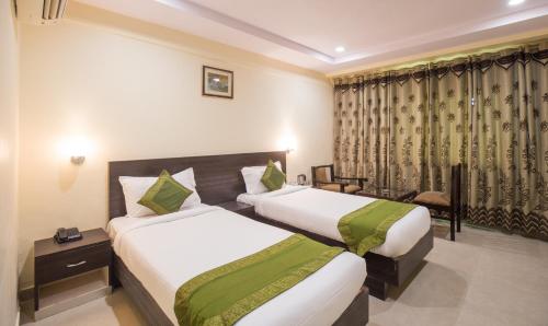 a hotel room with two beds and a window at Hotel City Center Jodhpur in Jodhpur