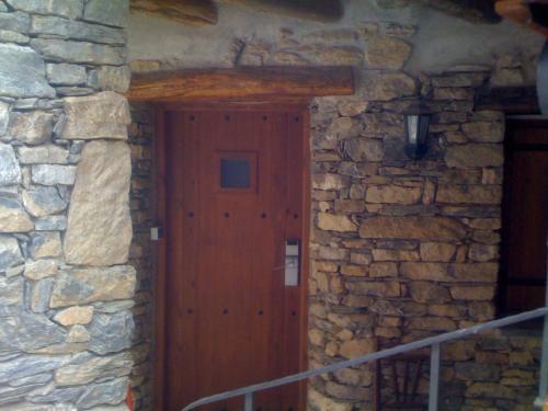 
a wooden door leading to a stone building at Roch Hotel in Altrón

