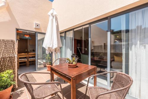 a patio with a table and chairs and a umbrella at Varanda do Castelo - Charming Apartment in a Historical Town in Silves