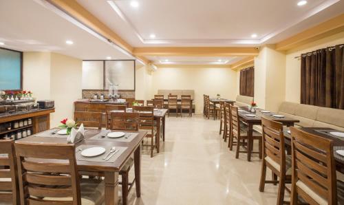a dining room with wooden tables and chairs at Hotel City Center Jodhpur in Jodhpur