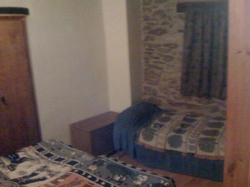 a small bedroom with a bed and a wooden cabinet at Roch Hotel in Altrón