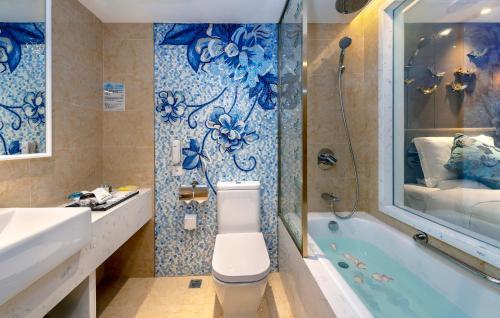 a bathroom with a bath tub, toilet and sink at Emperor Hotel in Macau