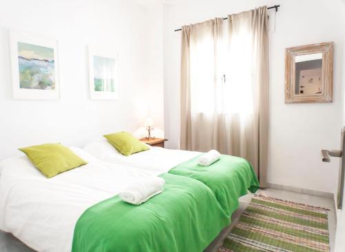 セビリアにあるArcheros Suite by Valcambreのベッドルーム1室(ベッド2台、緑のシーツ、窓付)