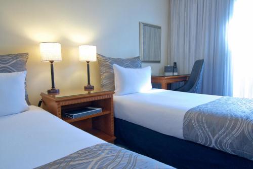 ein Hotelzimmer mit 2 Betten und 2 Lampen in der Unterkunft Soho Brisbane in Brisbane