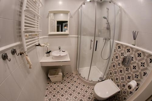 a bathroom with a shower and a toilet and a sink at Szafirowy Dwór Hotel & Restauracja in Gliwice