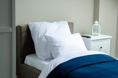 a bed with white pillows on top of it at Szafirowy Dwór Hotel & Restauracja in Gliwice