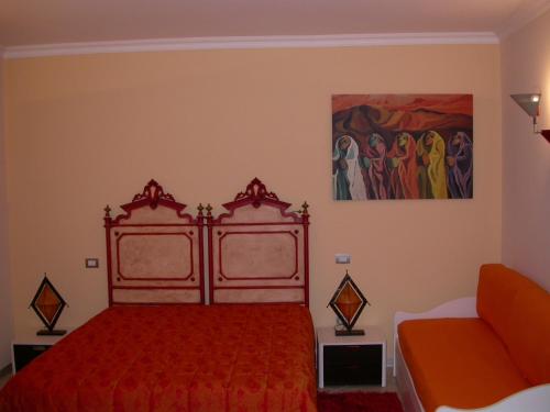 a bedroom with a red bed and a painting on the wall at Bed & Breakfast Palazzo Ducale in Andria