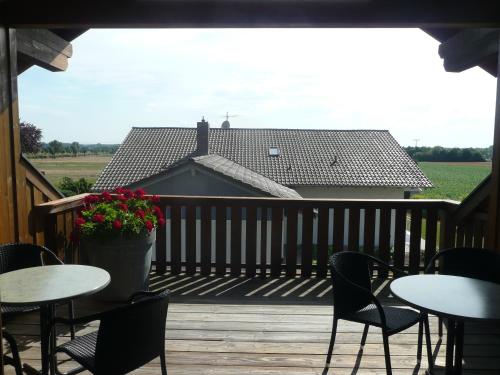 a deck with tables and chairs and a house at Privatpension Eberth in Bogen