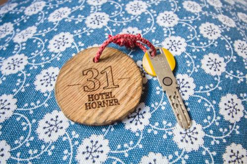 a wooden tag with a pair of scissors on a table at Hotel Hornerpub in Lauterbrunnen