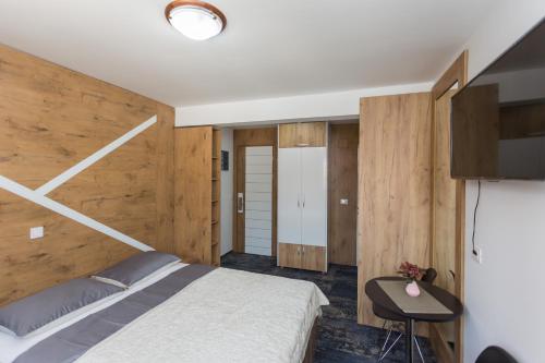 Un dormitorio con una cama, un escritorio y un televisor. en Tilia, en Cetinje