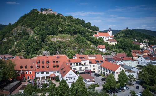 a town on a hill with houses and a mountain at Posthotel Walhalla Regensburg Ost in Donaustauf