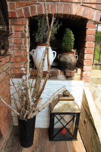 a brick wall with potted plants and a lantern at Art apartman in Kakanj