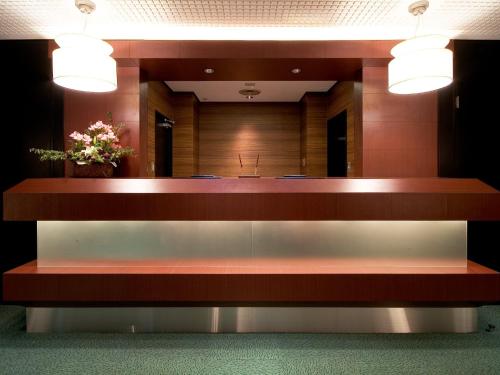 a reception desk in a hospital lobby with two lights at Hotel AreaOne Fukuyama in Fukuyama