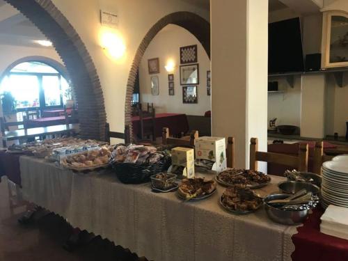 a table with plates and bowls of food on it at Hotel Panoramico in Corfino