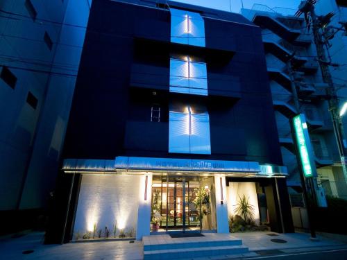 a blue building with windows at night at Hotel AreaOne Fukuyama in Fukuyama