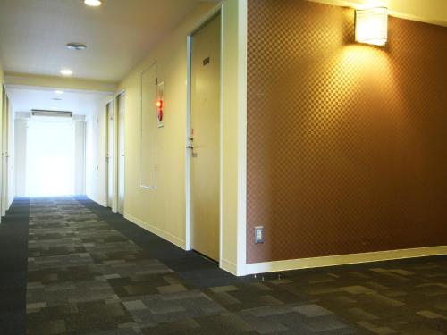 a hallway with orange walls and a door and a hallwayngthngthngthngthngth at Hotel AreaOne Fukuyama in Fukuyama