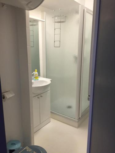 a white bathroom with a shower and a sink at Sète - vue mer imprenable, piscine, calme in Sète