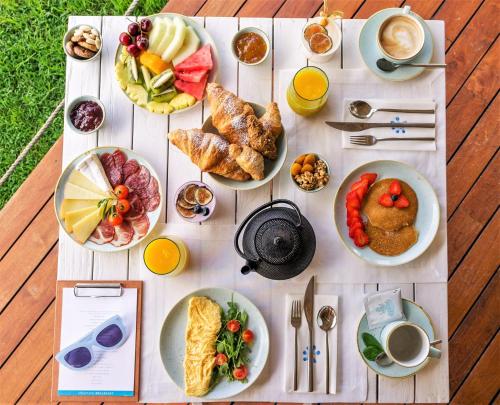 a table topped with plates of food on a table at Gecko Hotel & Beach Club in Playa Migjorn