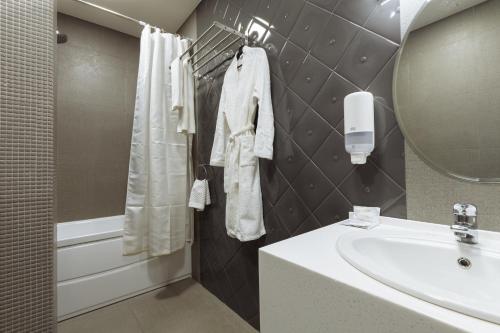 a bathroom with a sink and a mirror at Simpatico Apart-hotel Tyumen centre in Tyumen